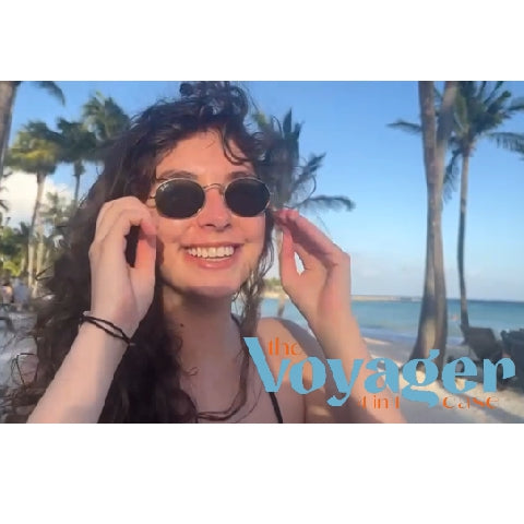 Smiling woman in round sunglasses on a tropical beach with palm trees, sunny weather